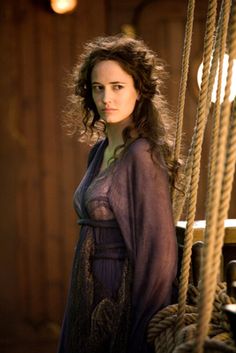 a woman standing on top of a boat next to ropes