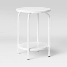 a small white table with black legs and a round top on the bottom, in front of a gray background