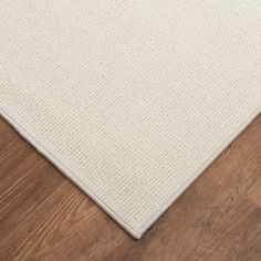 a white rug on top of a wooden floor