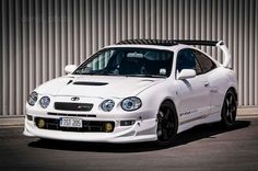 a white sports car parked in front of a building