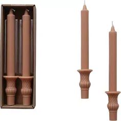 three wooden candles are in a box and one candle is on the other side of the box