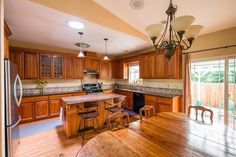 a large kitchen with wooden floors and cabinets