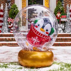 an inflatable snow globe with a penguin on it