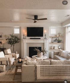 a living room filled with furniture and a flat screen tv mounted on the wall above a fire place