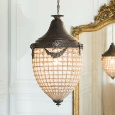 a chandelier hanging from a ceiling next to a mirror