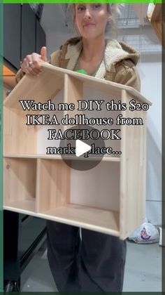 a woman holding up a wooden dollhouse from facebook