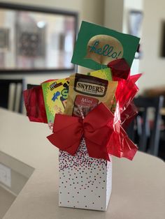 a small gift box with candy and candies in it on a table at a school