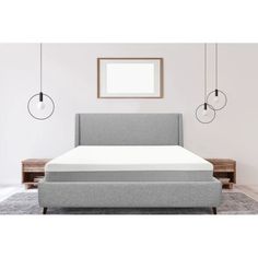 an image of a bed that is in the middle of a room with white walls