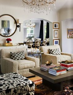 a living room filled with lots of furniture and a chandelier hanging from the ceiling