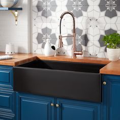 a kitchen with blue cabinets and white tile backsplashing, copper faucet