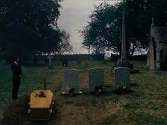 a man standing in front of a cemetery