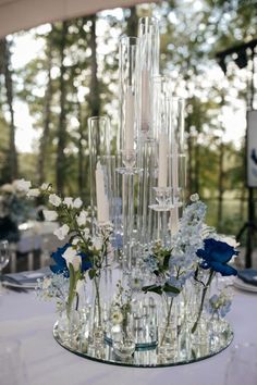 the centerpiece is made out of glass bottles and flowers, with candles in them