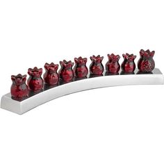 a set of seven red vases sitting on top of a white shelf