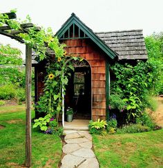 a small wooden house sitting on top of a lush green field