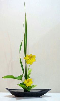 a black bowl with yellow flowers in it