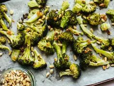 broccoli florets and pine nuts on a baking sheet