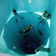 three people are swimming in the water with their feet on the edge of an underwater pool