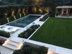 an outdoor pool surrounded by greenery and lighting