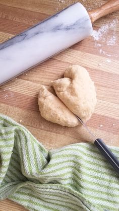 doughnuts and rolling pin sitting on a wooden table next to a towel with a rolling pin