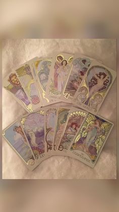 four tarot cards with angels on them sitting next to each other, all in different colors