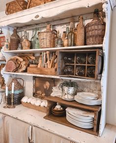 an old china cabinet is filled with dishes and other kitchen utensils in baskets