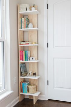 a bookshelf in the corner of a room next to a door and window