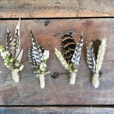 four feathers and flowers are arranged on a wooden surface