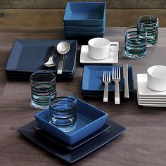 a table set with blue dishes and silverware