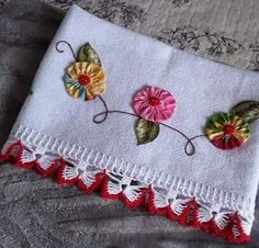 a close up of a piece of cloth on a bed with flower appliques