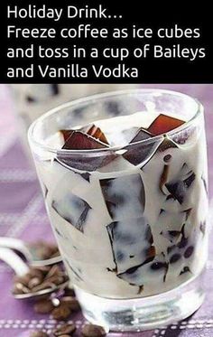 a glass filled with ice cream sitting on top of a table next to coffee beans