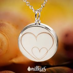 a white pendant with two hearts on it