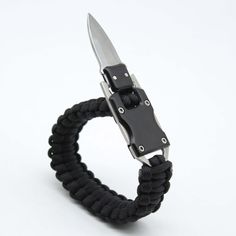 a black paracorine bracelet with a knife in it's center on a white background