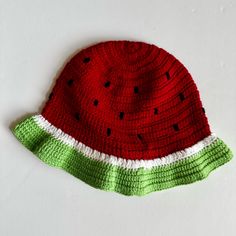 a knitted watermelon hat on a white surface