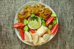 a white plate topped with lots of different types of food on top of a table