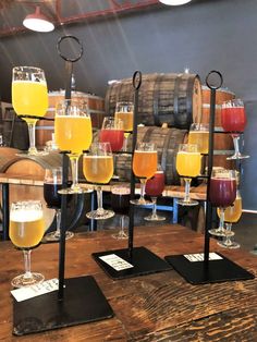 several different types of drinks are on display in front of wine casks and barrels