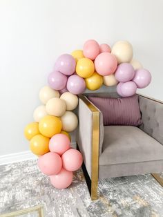 a chair with balloons attached to it in front of a white wall and carpeted floor