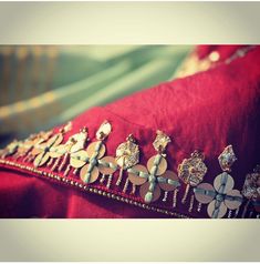 a red pillow with gold and silver jewelry on it