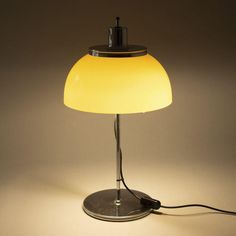 a lamp that is sitting on top of a table next to a light bulb and plugged in