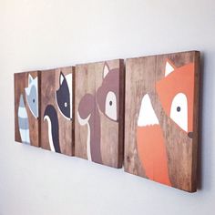 three wooden wall hangings with animals painted on them