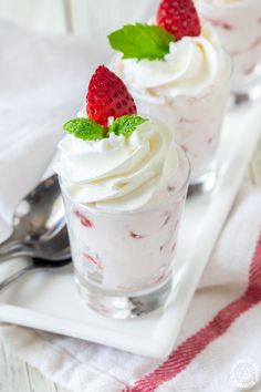 two desserts with whipped cream and strawberries on top