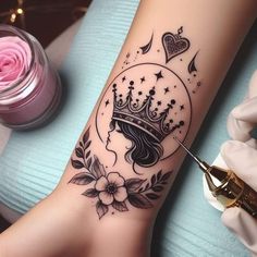 a woman's foot with a crown tattoo on the side of her leg and flowers around it