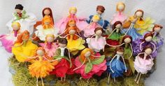 a bunch of dolls that are sitting on some grass