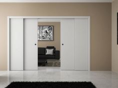 an open door leading to a living room with black and white rug on the floor