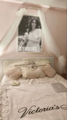 a bed with a poster above it that says victoria's