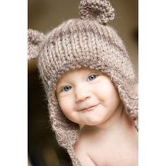 a smiling baby wearing a knitted hat