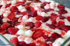 a dessert with strawberries and cream in a glass dish on top of a table