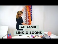 a woman standing in front of a white wall with balloons on it and the words all about link - o - loons