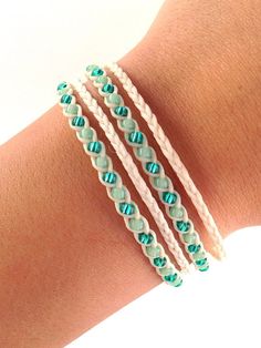 a woman's arm with three different bracelets on top of it and one has blue beads