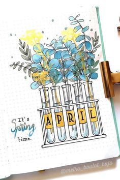 an open notebook with flowers in test tubes on the cover, and some keys next to it