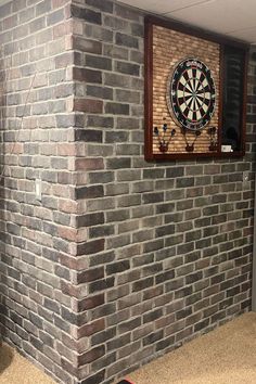 a brick wall with a dart in the center and darts on the wall next to it